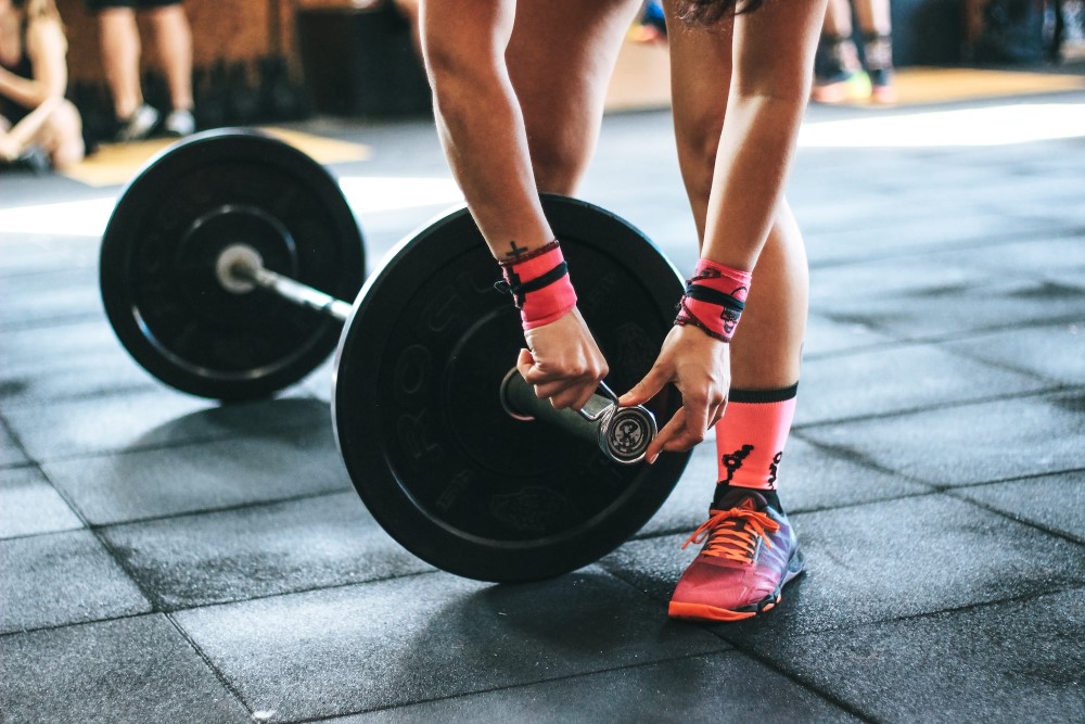 person putting weights on barbell