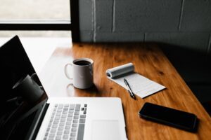 Picture of computer, coffee, and notepad on desk